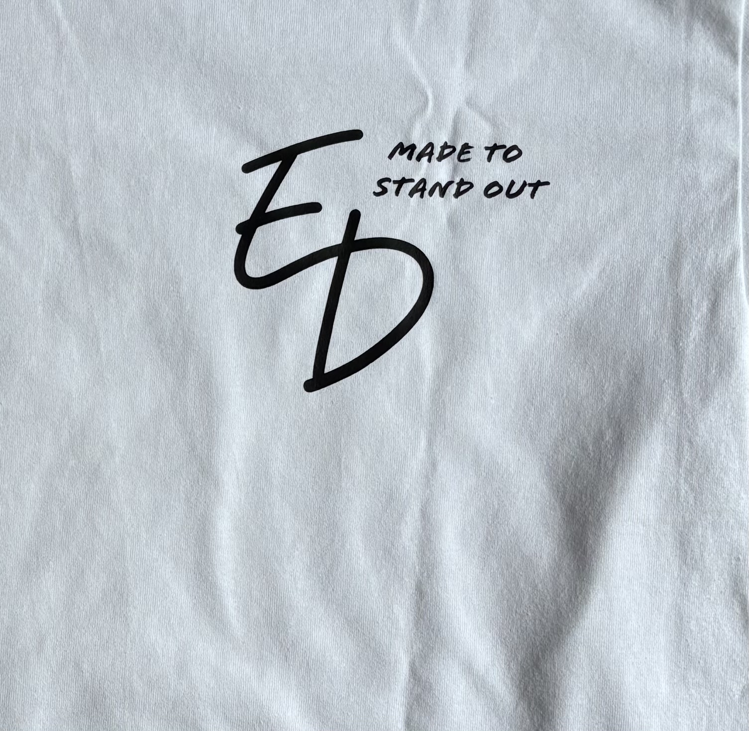 Close-up of the actual black ED Made to Stand Out print on a white T-shirt