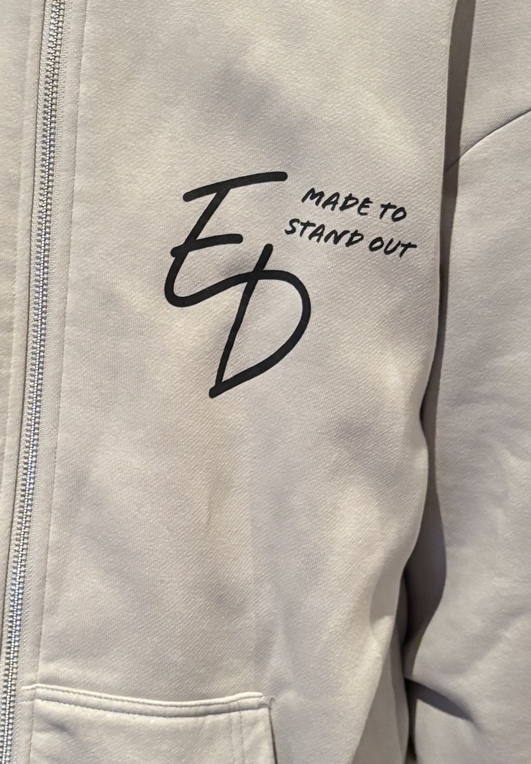 Close-up of the actual zip and ED Made to Stand Out print on the zip hoodie